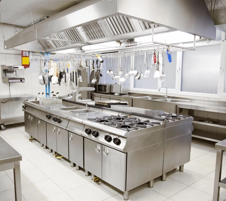 A kitchen with many stainless steel appliances and white tile.