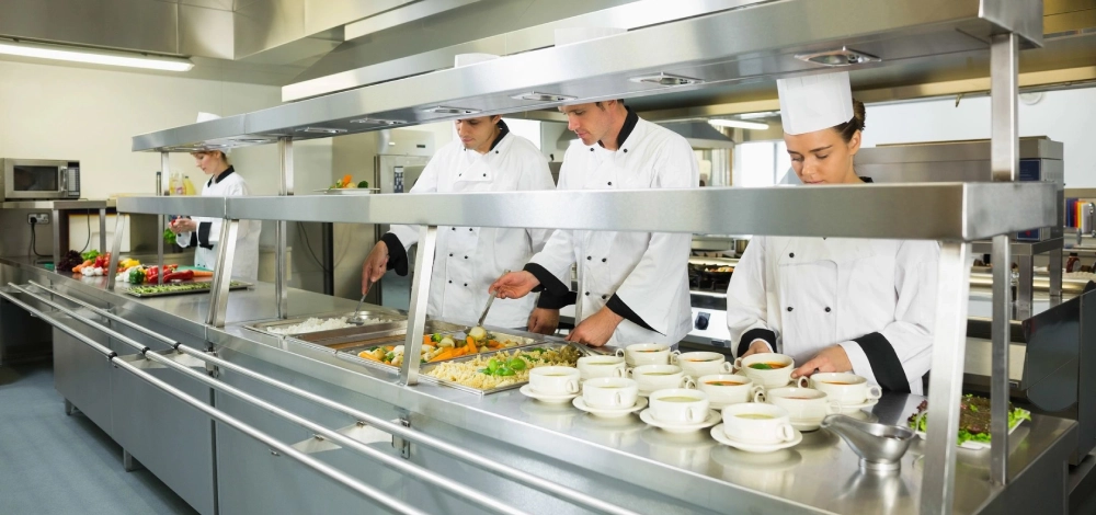 A group of chefs preparing food in a kitchen.