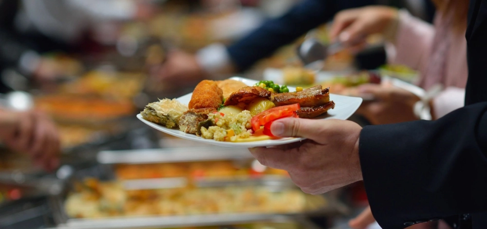 A person holding a plate of food in their hand.