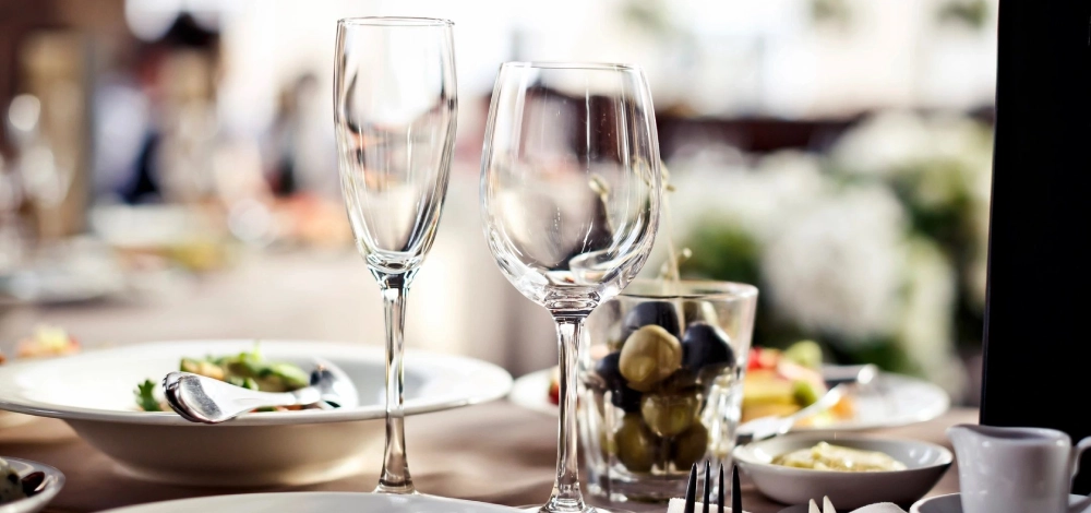 A table with wine glasses and olives on it.