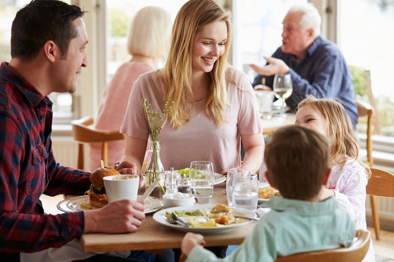 A group of people sitting at a table with food.