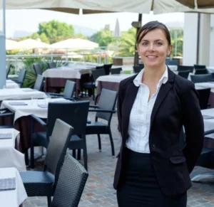 A woman standing in front of an outdoor restaurant.