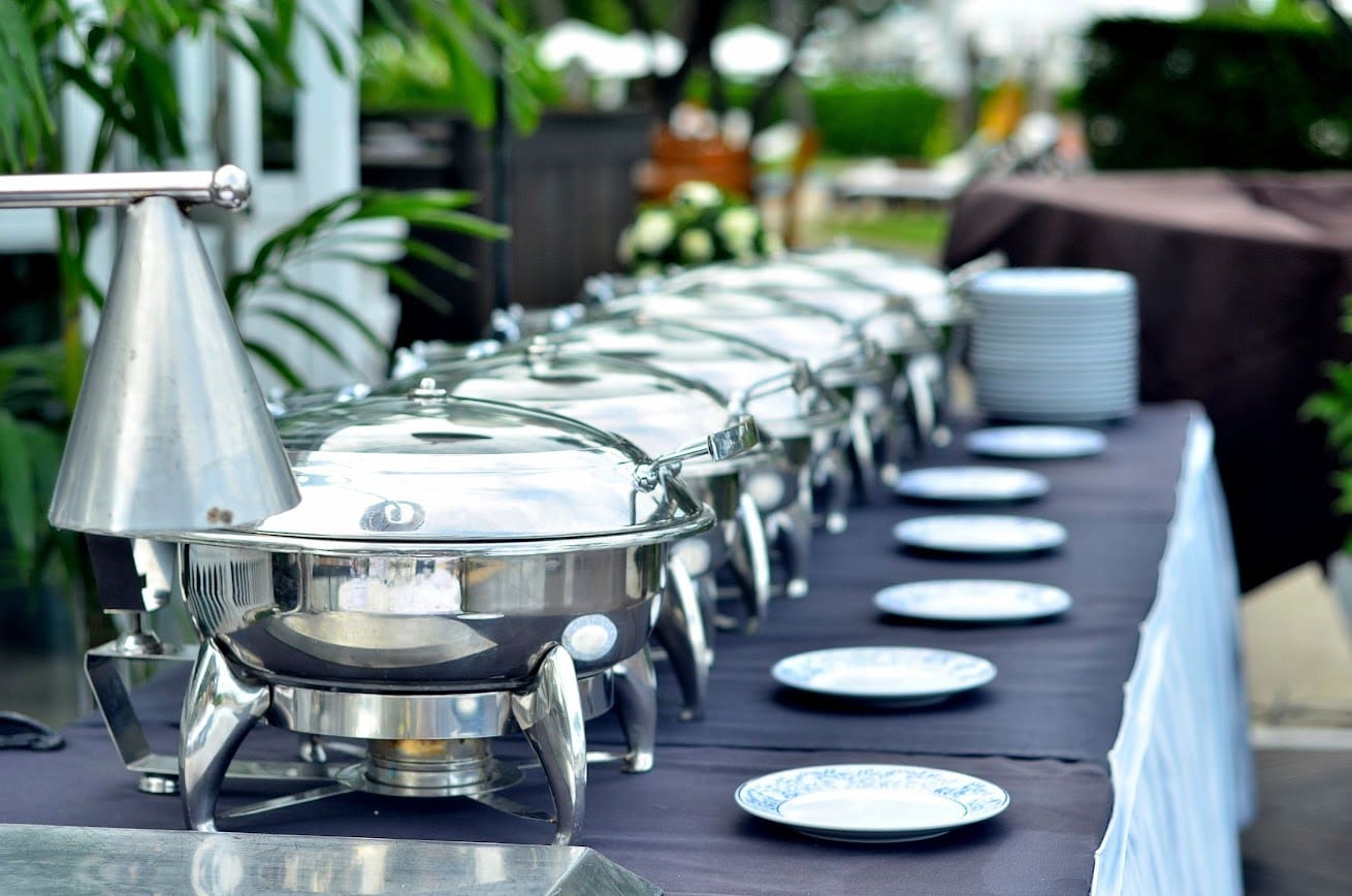 A row of silver dishes lined up on top of a table.