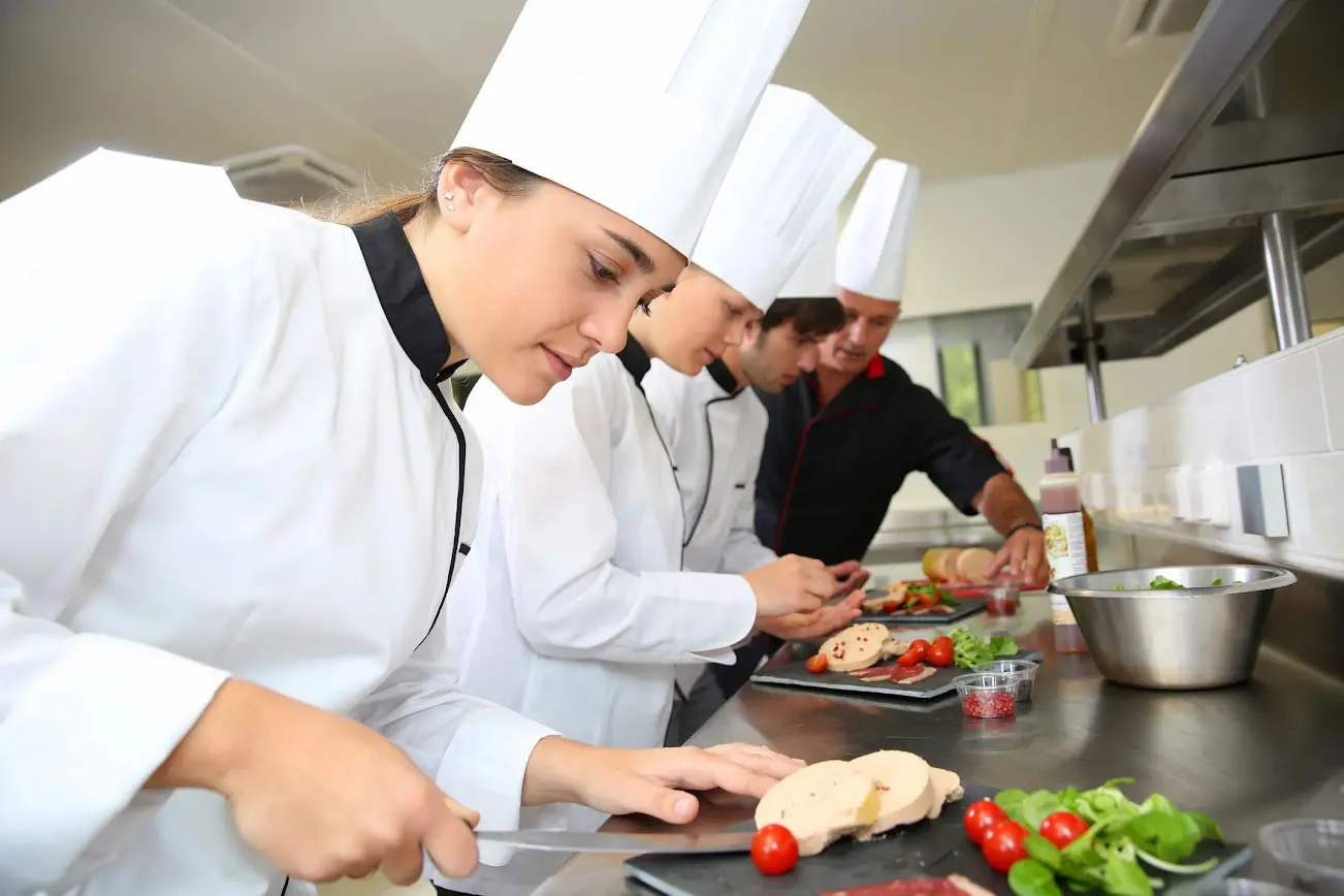 A group of chefs preparing food in a kitchen.